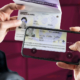 Illustration of scanning the machine-readable zone, MRZ, of a passport with the mobile phone: A person holds the open passport in her right hand and a smartphone with activated camera and scan function in her right hand, the MRZ is being captured.